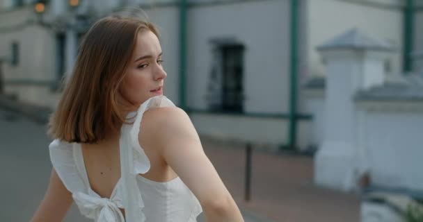 Portrait of the woman dancer in white dress that dances gracefully in slow motion outdoors, balerina does dance pa and movements outdoors, 4k 120 fps Prores HQ — Stok video