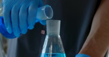 Laboratory medic pours chemical substance from flask to the flask. Medications and vaccine development, 4k Prores