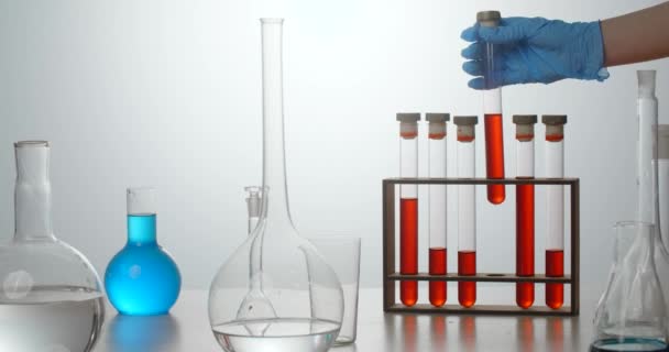 研究室のアシスタントは、実験台に血液と試験管を置きます.薬やワクチンの開発。血液検査室 — ストック動画