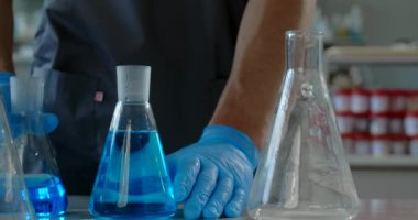 Laboratory medic pours chemical substance from flask to the flask. Medications and vaccine development, 4k Prores