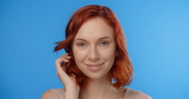 Рыжая красивая женщина позирует в видео о красоте на синем экране. Модель блеванет волосами на фотосессии. Штаб-квартира 4k Прорес — стоковое видео