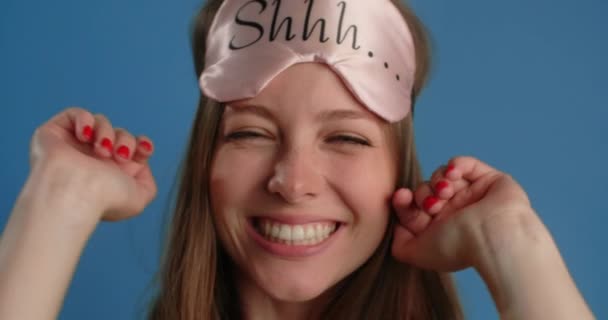 Young woman takes off the sleeping mask and smiles, sticks out her tongue and grimaces, 4k 60p Prores HQ — Wideo stockowe