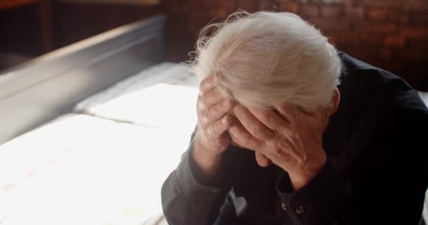 Depressed hopeless old gray haired man grieves and grabs his head with both hands, sorrow and mental breakdown, 4k 60p Prores — Stock video