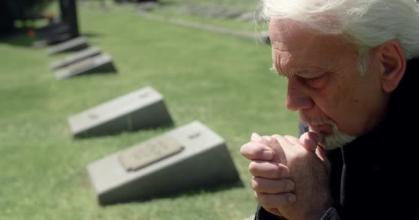 Smutný šedovlasý muž se modlí na hrobě na hřbitově, smutek a smutek nad ztrátou blízkých, 4k 60p Prores — Stock video