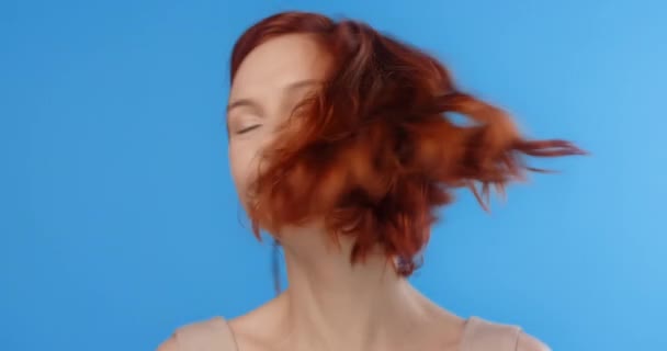 빨간 머리예쁜 여자가 머리를 굴려 파란 화면에 머리를 던집니다. 모델 이 사진찍을 때 머리를 던집니다. 4k 가 HQ 를 만들다 — 비디오