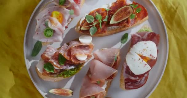 Tischaufnahmen vom Spinnteller mit Bruschettes mit Salami, Schinken und Prosciutto, 4k 60p Prores — Stockvideo