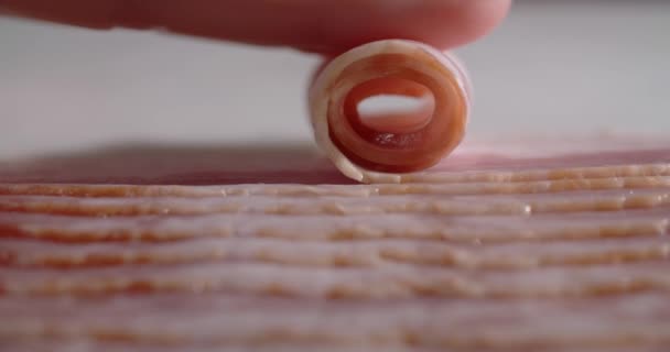 Macro tiro da fatia de bacon é enrolado pelo dedo. Pratos com bacon e carne de porco, 4k 60p Prores — Vídeo de Stock