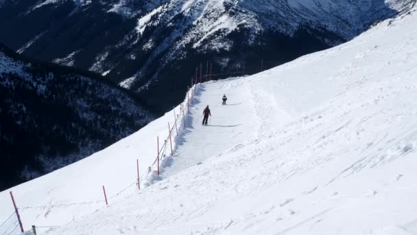 Narciarze jeżdżą na nartach po stokach w górach, na nartach górskich, 4k 60p — Wideo stockowe