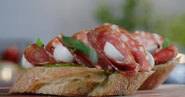 Bruschette with salami and mozarella is sprinkled by the raw green herbs in slow motion, 4k 60p Prores — Stock Video