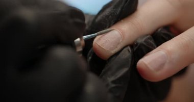 Güzellik uzmanı, özel bir aletle manikür prosedürü yapıyor. Güzellik salonunda kozmetik prosedürler, 4k Prores 60 peni.