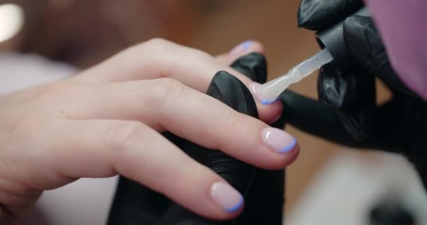 Manicure brengt gel lak aan op de nagels van de klant in beaty salon, cosmetologie en beauty business, 4k Prores 60p — Stockvideo