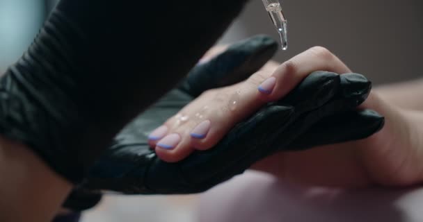 Esthéticienne dépose de l'huile sur les ongles du client, procédures beautycare, entreprise de cosmétologie, 4k Prores 60p — Video