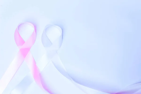 pink ribbon fight breast cancer and blue ribbon fight child abuse isolated with space for text on blue background.
