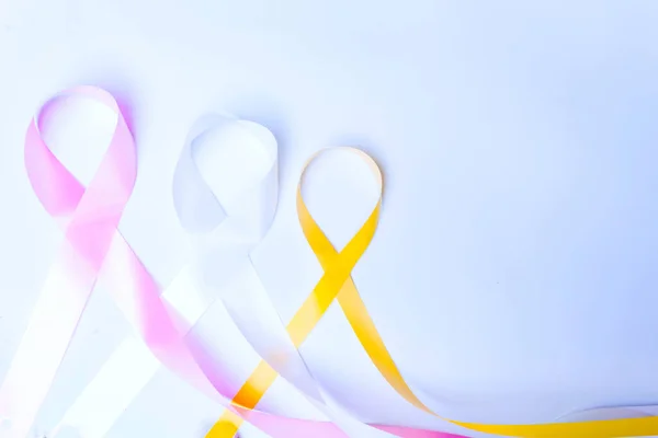 Pink Ribbon, Fight Breast Cancer, Blue Ribbon, Fight Child Abuse, Yellow Ribbon, Fight Suicide Prevention, Isolated with room for text on blue background.