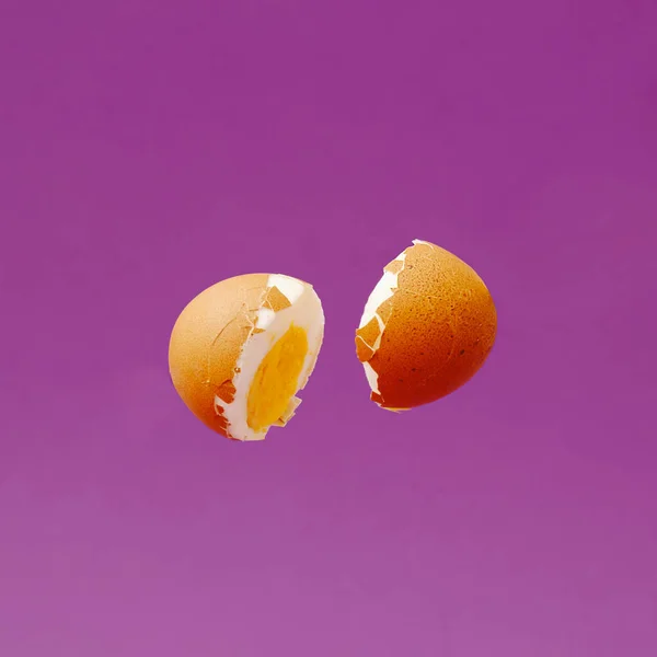 紫色の背景に空気中で調理卵をカット 最小限の創造的な組成物 — ストック写真