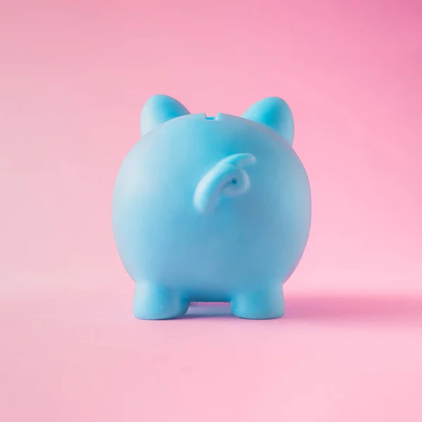 minimal creative composition of the blue piggy bank on the pastel pink background.to save money.