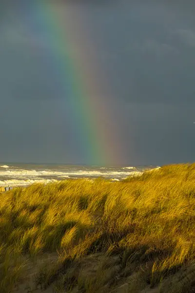 Arka planda gökkuşağı olan kumullar