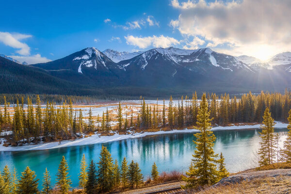 Sun Glowing Over Banff Mountains And River