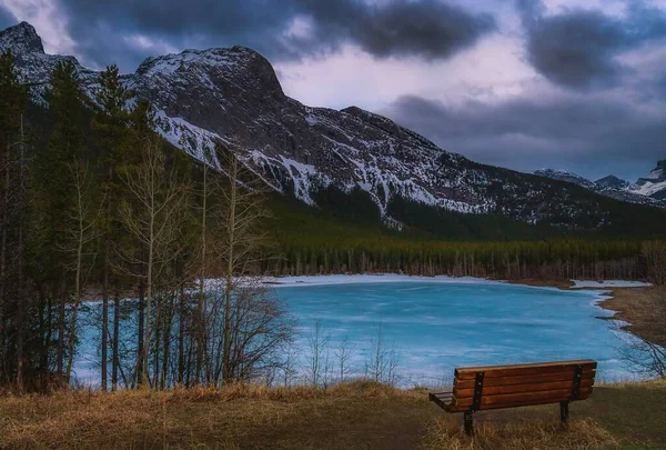 在结冰的高山湖上张望的长椅 — 图库照片