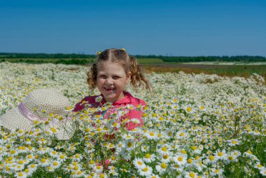 Çiçekli papatyalarla koca bir tarlada yürüyen bir kız.. 