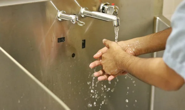 在手术室的洗手间里用消毒肥皂擦拭双手 擦拭可以大大降低感染的风险 — 图库照片