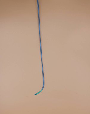 Kalp atardamarlarındaki tıkanıklığı tedavi etmek için kullanılan anjiyoplasti kılavuz sondası. Resim bej arkaplanda izole edildi