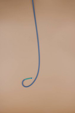 Kalp atardamarlarındaki tıkanıklığı tedavi etmek için kullanılan anjiyoplasti kılavuz sondası (EBU kateter). Resim bej arkaplanda izole edildi