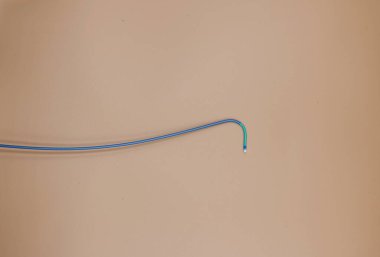Kalp atardamarlarındaki tıkanıklığı tedavi etmek için kullanılan anjiyoplasti kılavuz sondası. Resim bej arkaplanda izole edildi
