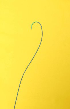 Kalp atardamarlarındaki tıkanıklığı tedavi etmek için kullanılan bir anjiyoplasti kılavuz sondası (EBU sondası). Resim sarı arkaplanda izole edildi