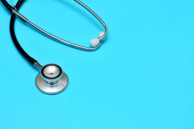 Mavi arka plana yerleştirilmiş steteskop. Sağlık sigortası kavramı