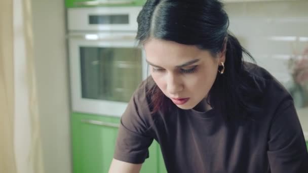 Giovane donna caucasica in t-shirt cottura biscotti su un tappetino di silicone a casa cucina — Video Stock