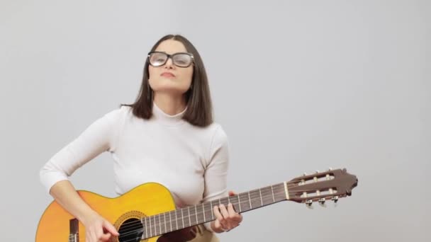 Γυναίκα με μπεζ στολή που παίζει σόλο με καμπές στην ακουστική της κιθάρα — Αρχείο Βίντεο