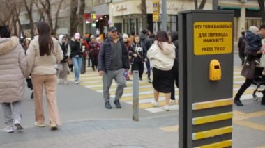Almaty, Kazakistan - 21 Mart 2022: Ağır çekimde Gogol Caddesi 'nden karşıya geçen yayalar