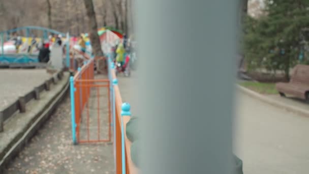 Одинокая молодая женщина в зеленом пальто в парке — стоковое видео