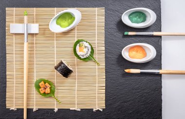 Japon yemek tabağı, suşi ve maki sunumu siyah zemin üzerinde fırça ve boya dekorasyonu ile.