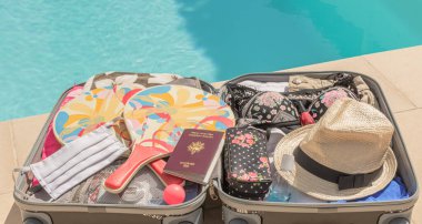 Tekerlekli bavul, yüz koruması için maske ve covid-19 virüsü, koronavirüs, alerji, salgın hastalık ve pandemiye karşı savaşmak için hidroalkolik jelle gezilere çıkıyor..