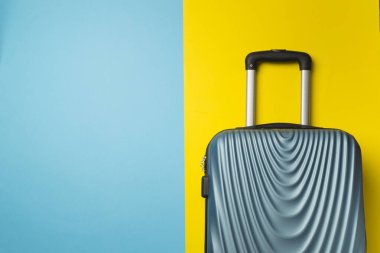 Renkli arka planda mavi bavul, üst görünüm.