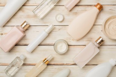 Ahşap arka planda farklı kozmetik şişeler ve konteynırlar..