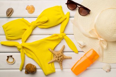 Güzel sarı bikini ve aksesuarlar renkli ahşap arka plan, üst manzara.