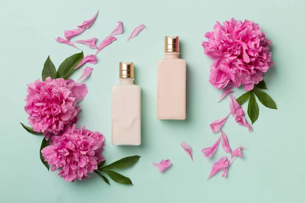 Platte Lay Compositie Met Cosmetische Flessen Pioenroos Bloemen Kleur Achtergrond — Stockfoto