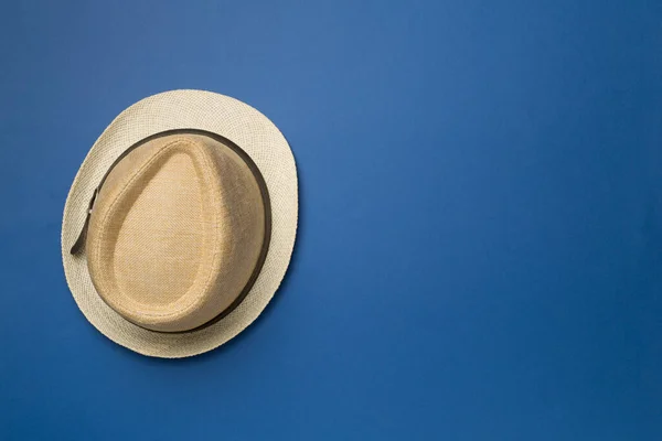 Straw hat on color background, top view.
