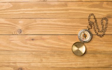 Old vintage compass on wooden background. Top view.