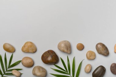 Renk arkaplan üzerinde spa taşları ve yapraklar, üst görünüm.