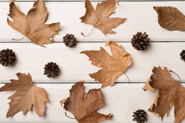 Ahşap zemin üzerinde sonbahar yaprakları ile düz kompozisyon, üst görünüm.