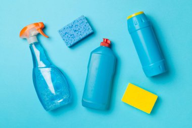 Renk arkaplanı ve üst görünümde birçok farklı ev temizleme ürünleri.