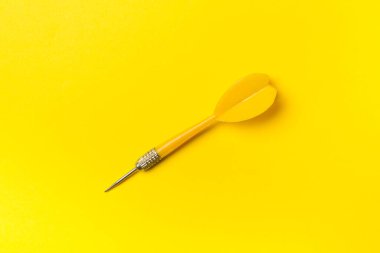 Yellow darts on color background, top view.