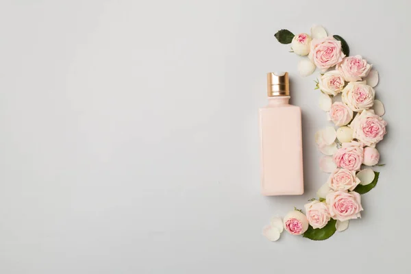Cosmetic Bottle Rose Flower Color Background Top View — Stock fotografie