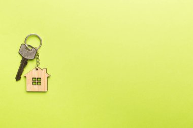 Renk arkaplanında ev şekilli anahtarlık.