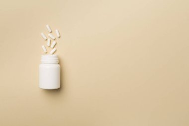 Arka planda haplar olan beyaz şişe..