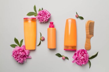 Şakayık çiçekli şampuan ve saç kremi ve renk arkaplan tarağı, üst görünüm.